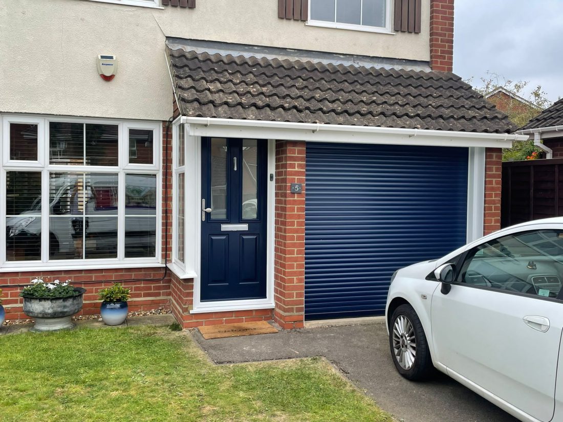 Composite front door with matching roller door in blue.