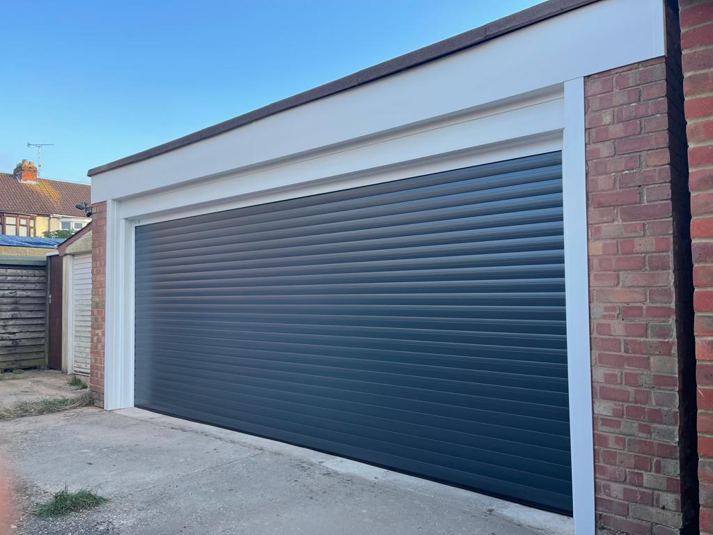 Brick garage being after being fitted with a new roller garage door in jet black.