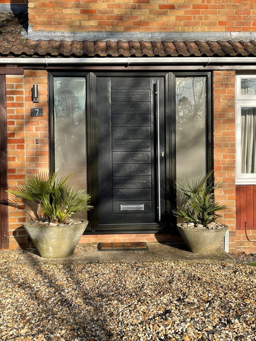 Newly fitted composite front door with obscure side panel windows and chrome fixings.