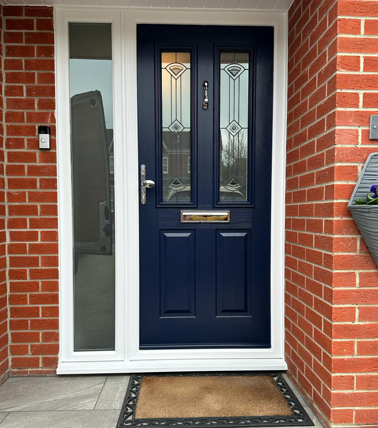 Composite front door in blue with stylised windows and chrome fixings.